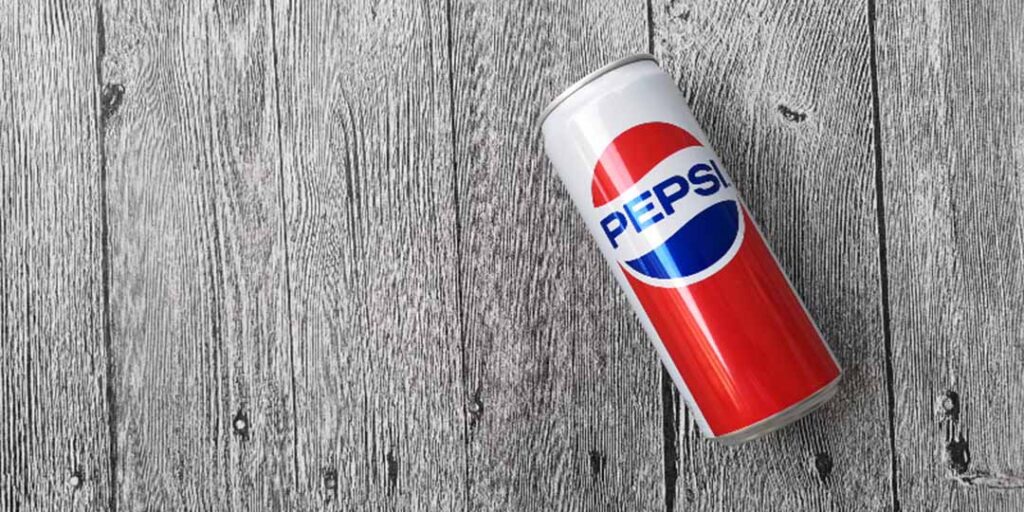 classic Pepsi can laying on a word wood background.