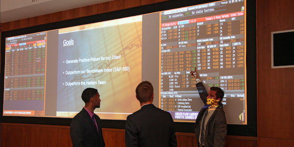 A group of three men looking at a investment screen