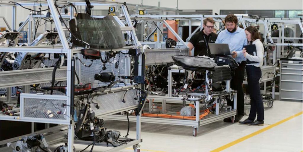 Engineers at work in a car manufacturing warehouse