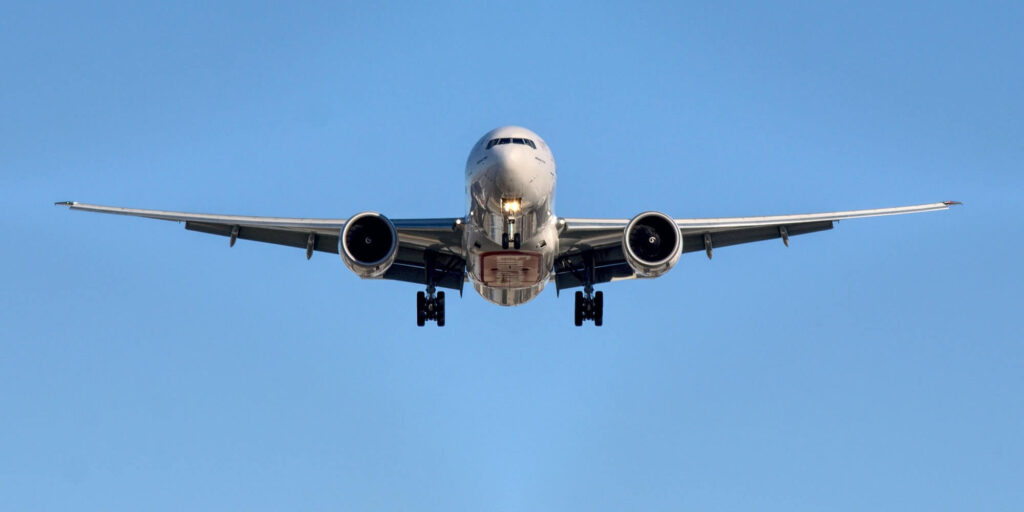 Front view of airplane in flight against blue sky