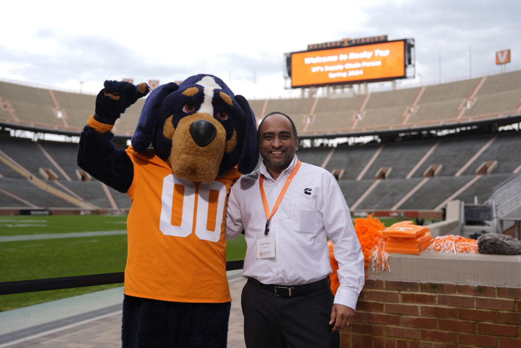 A Supply Chain Forum attendee poses for a photo with Smokey the mascot at a reception inside Neyland Stadium.