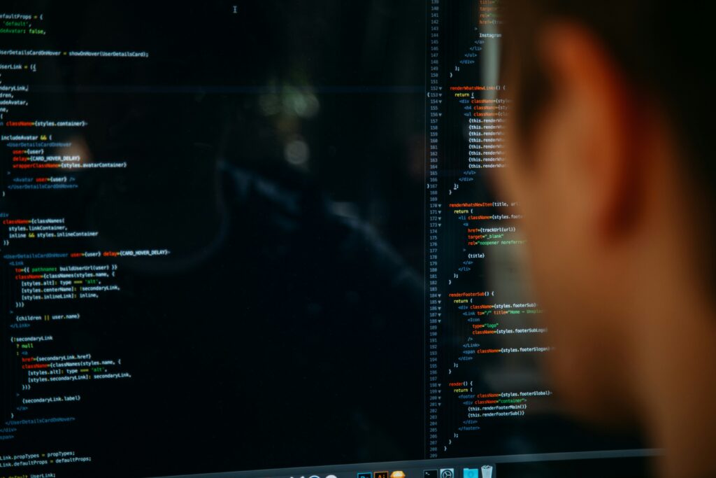 A hacker stares at code on a computer screen