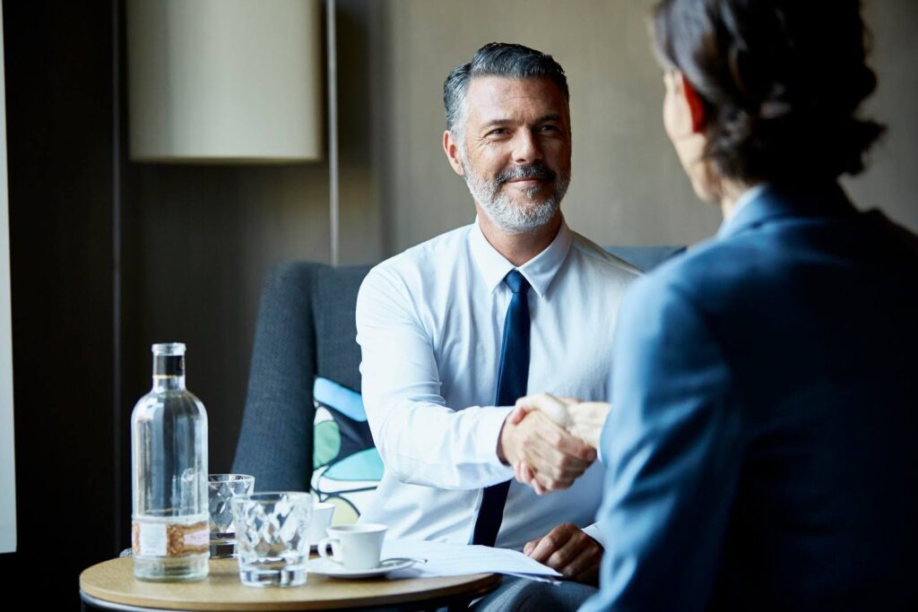 Participants in a business meeting shake hands.