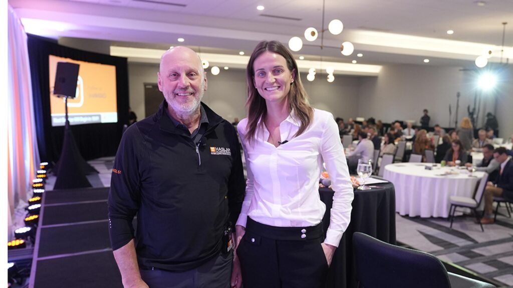 GSCI co-executive director Ted Stank and Schneider Electric's Jen Kelly pose for a photo on the stage at the Fall 2024 Supply Chain Forum.